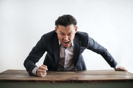 angry man hitting desk with fist
