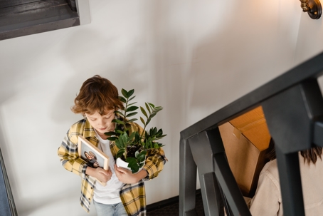 child walking downstairs with items in arms