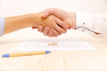 Partners shaking hands over prenuptial agreement